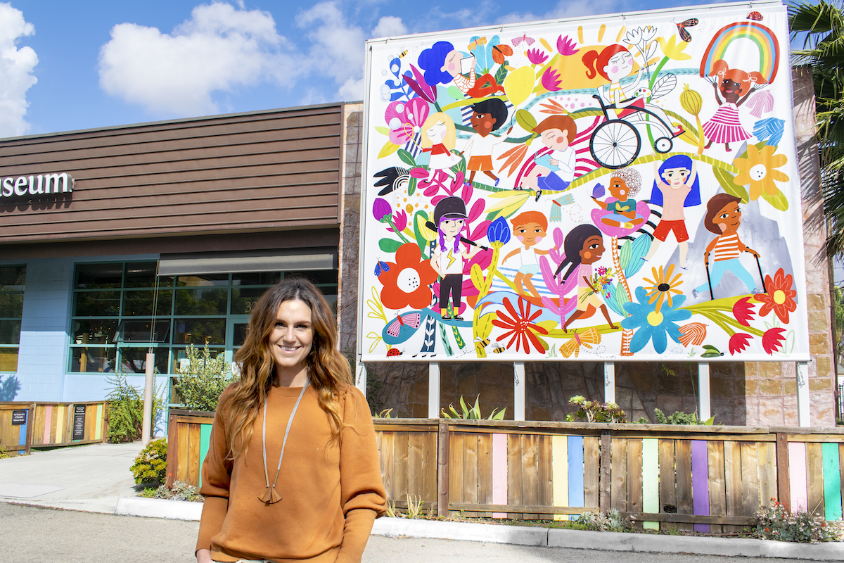Mollie Garre in front of her mural "Our Journey Together"